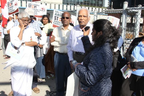 தமிழர் தாயகத்தில் வாழும் தமிழ்மக்கள் மீது சிறீலங்கா அரசு தொடுத்திருக்கும் இனவழிப்பை நிறுத்துமாறும் தமிழர் நில அபகரிப்பை எதிர்த்தும் தாயக மக்களின் போராட்டத்துக்கு வலுவூட்டும் வகையிலும் நேற்று செவ்வாய்க் கிழமை 36 எக்லின்டன் மேற்கு வீதியில் அமைந்திருக்கும் சிறீலங்கா துணைத் தூதுவராலயத்தின் முன் நூற்றுக் கணக்கான தமிழ் மக்கள் கைகளில் முழக்க அட்டைகளைப் பிடித்த வண்ணம் கொளுத்தும் வெய்யிலிலும் கூடி நின்று தமது எதிர்ப்பை வெளிக்காட்டினர். 